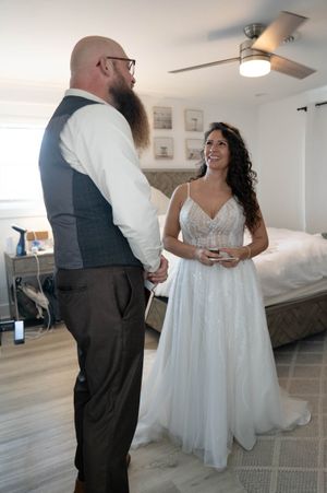 A couple shares a moment in a bright indoor space during their wedding celebration.