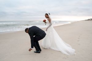 Artistic wedding photography poses on sandy beach with ocean backdrop.