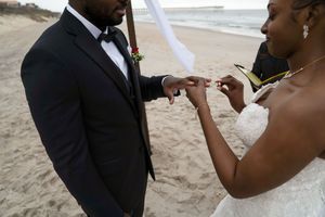 Exchange of rings during an intimate beach wedding ceremony.