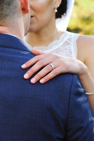 Close-up shots showing hands with wedding rings against a navy blue suit jacket.