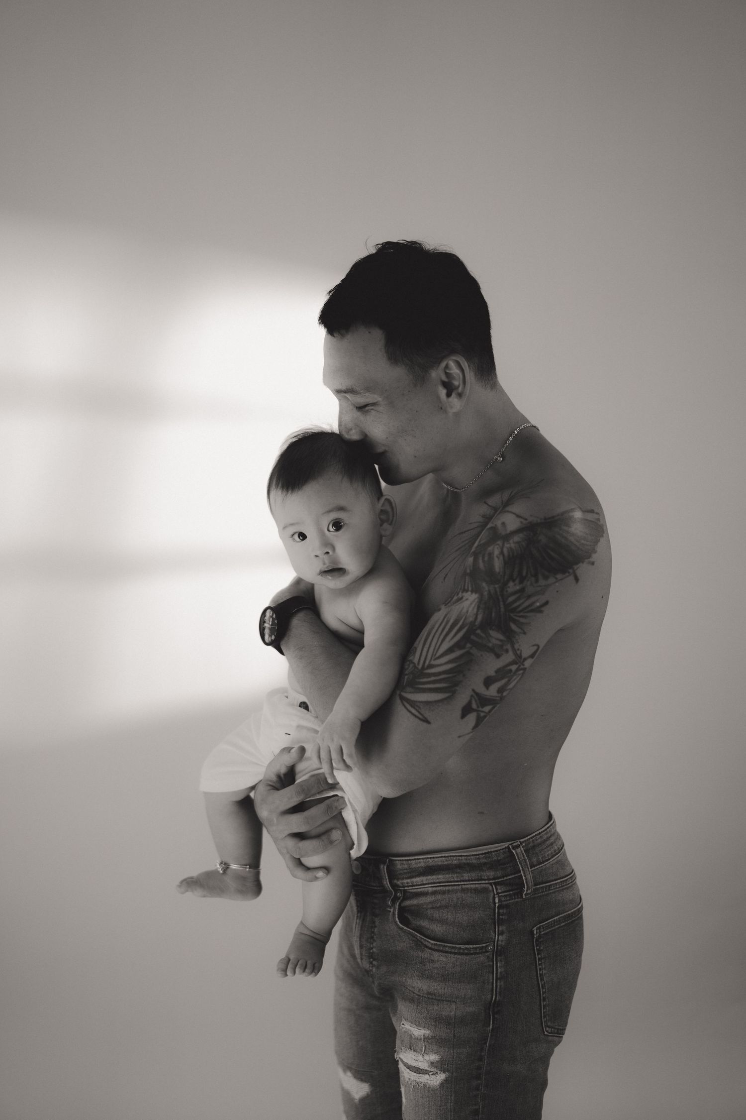 Black and white photo series showing tender moments between parent and baby in artistic candid poses.一組黑白照片，以藝術化的抓拍姿勢展現父母與嬰兒之間溫馨的瞬間。