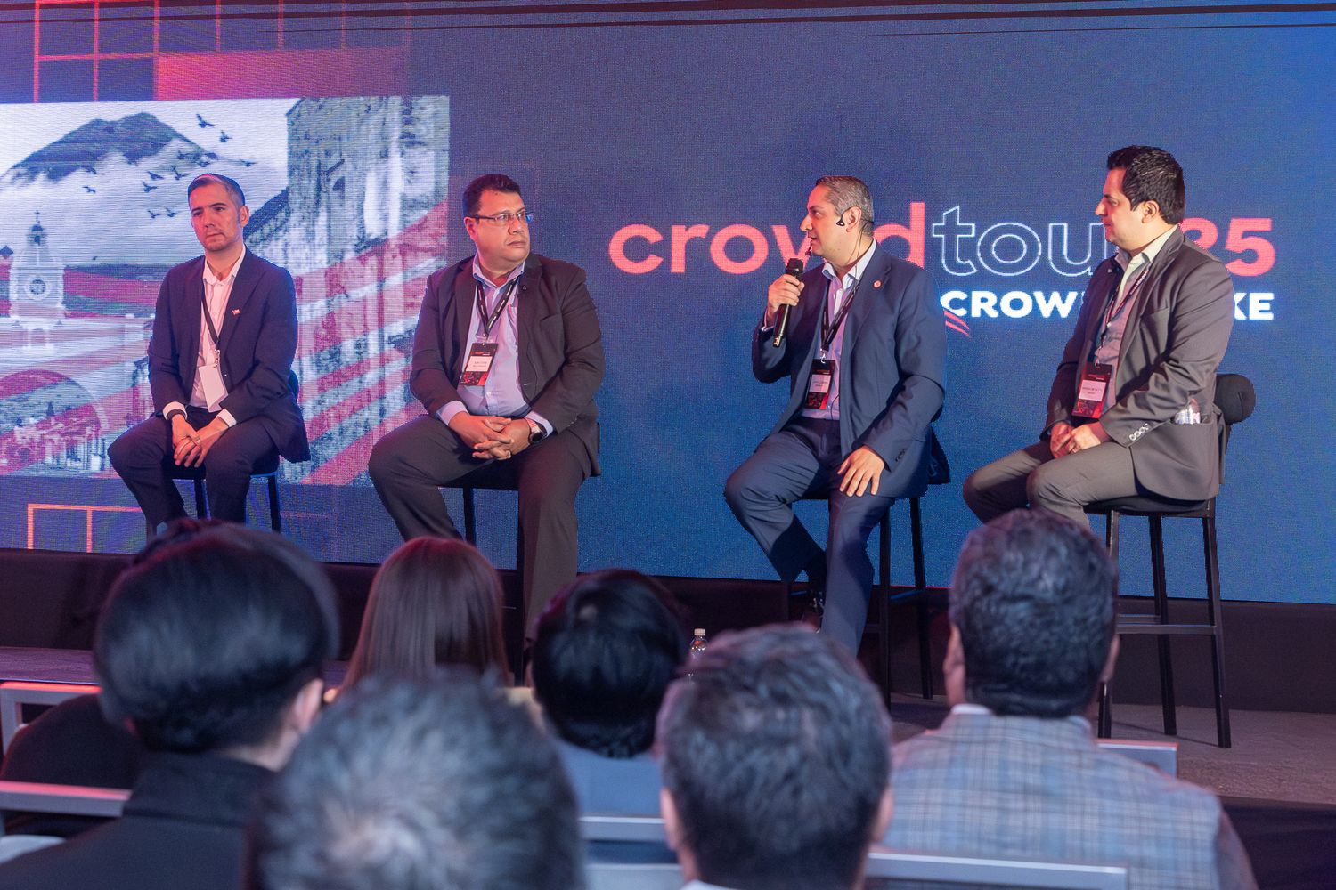 Business professionals engage in a panel discussion on stage at a corporate conference event.