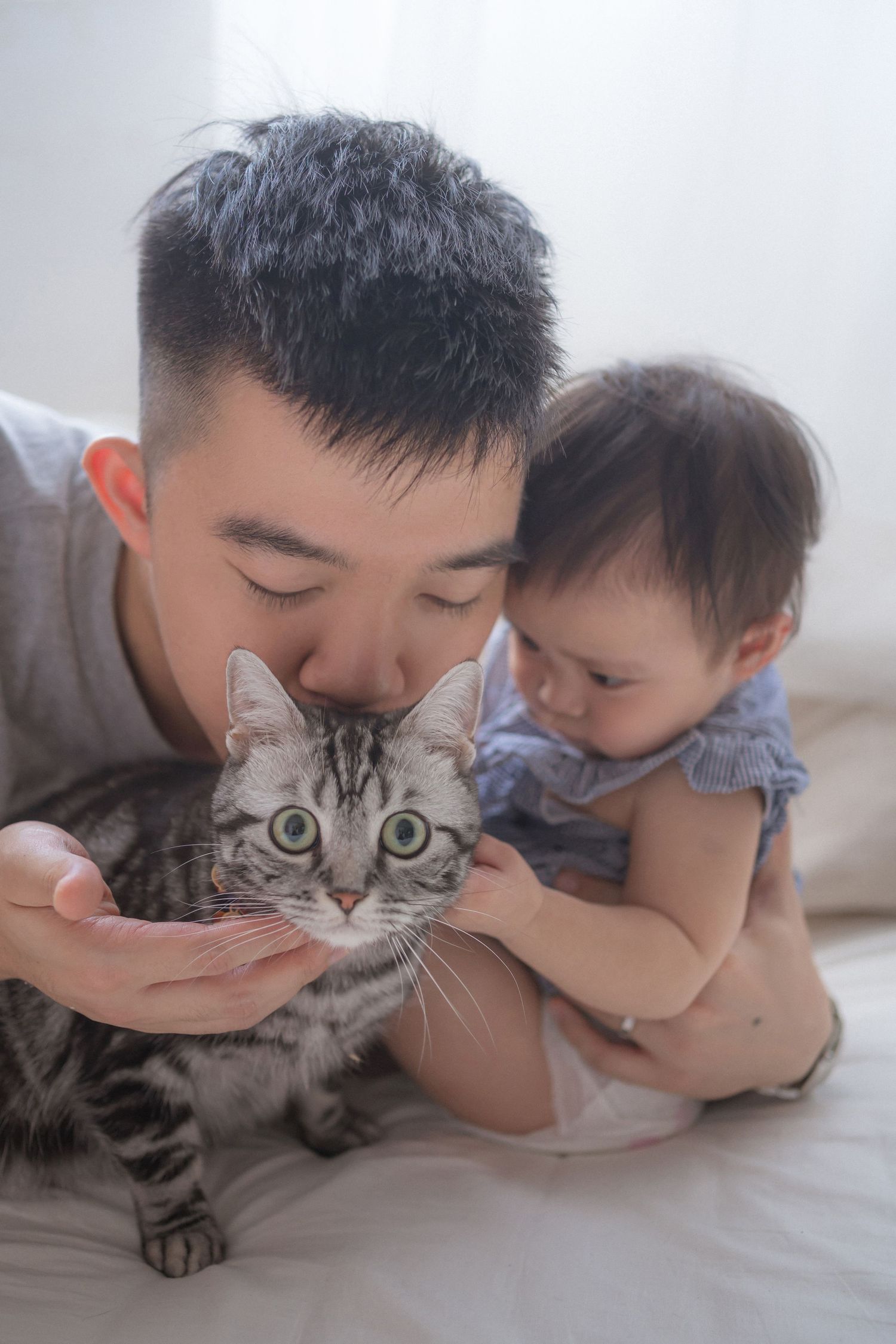 Family sits together on a white couch with pampas grass decor in a cozy minimalist setting.一家人圍坐在白色沙發上，周圍環繞著蘆葦草裝飾，營造出溫馨簡約的氛圍。