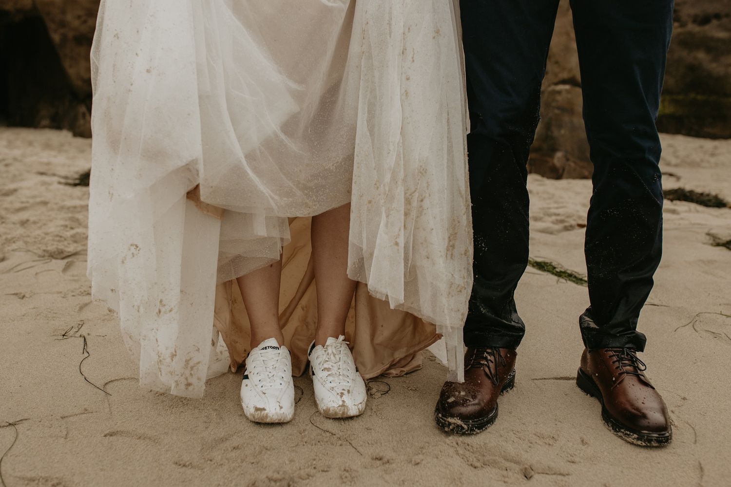 Close-up view of a bride and groom's formal shoes lined up at Windansea Beach in La Jolla.