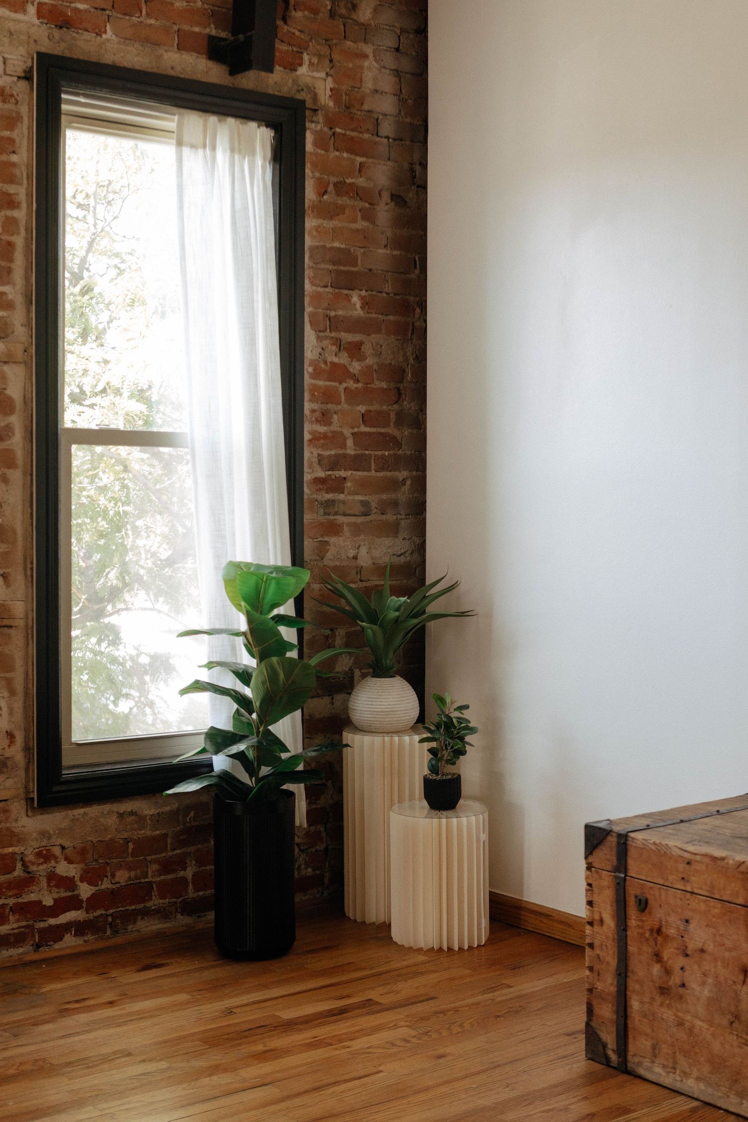 Black circular logo for The Aperture Loft featuring a floral design on a wooden floor in an open studio space.