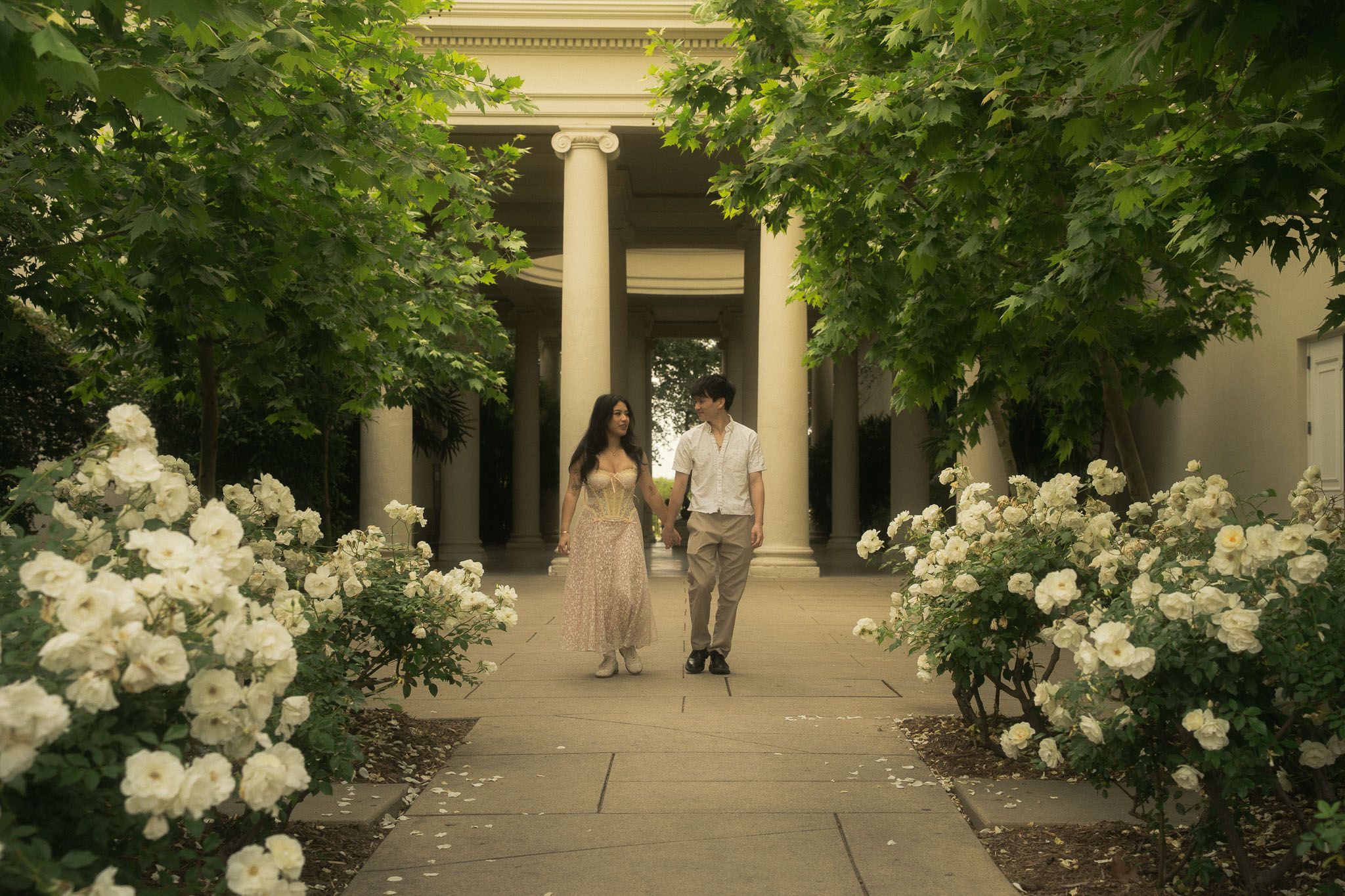 Cindy and Brandon walking through the rose garden during their engagement session at the Huntington Library in San Marino.