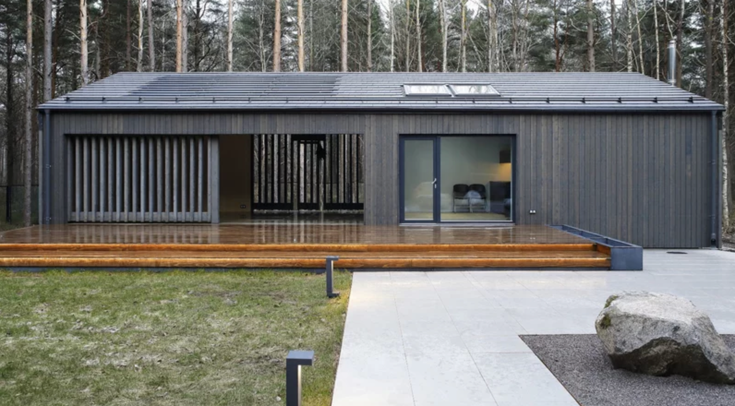 A panoramic view of a rustic wooden chalet nestled in the green hills of a mountainous countryside.