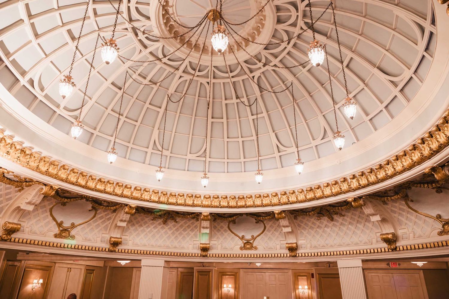 Ornate ceiling and chandelier lighting inside the Dome Room at the Lenox Hotel during a Boston wedding reception