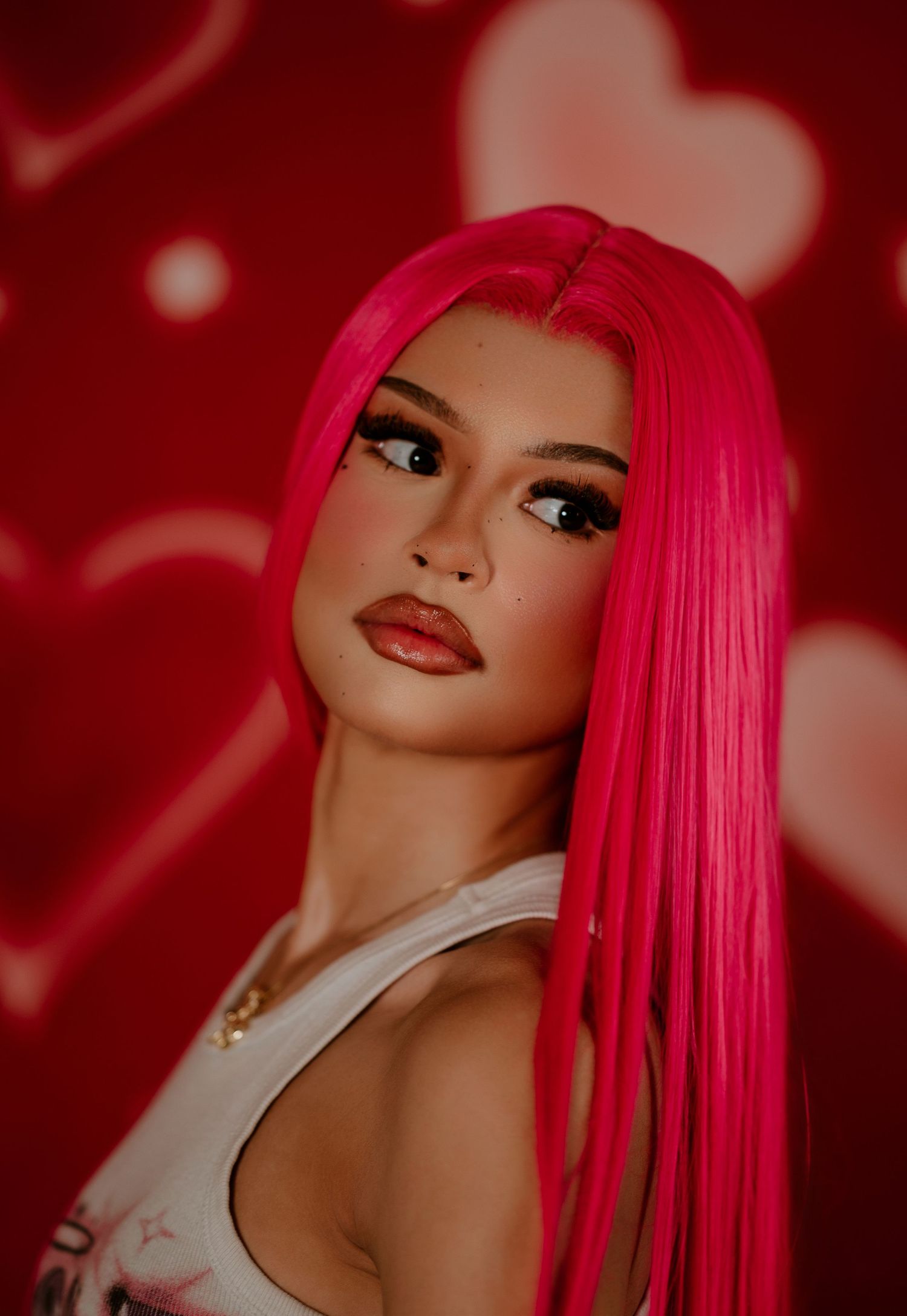 A series of portraits showing a model with vibrant pink hair against a red background with bokeh effects.