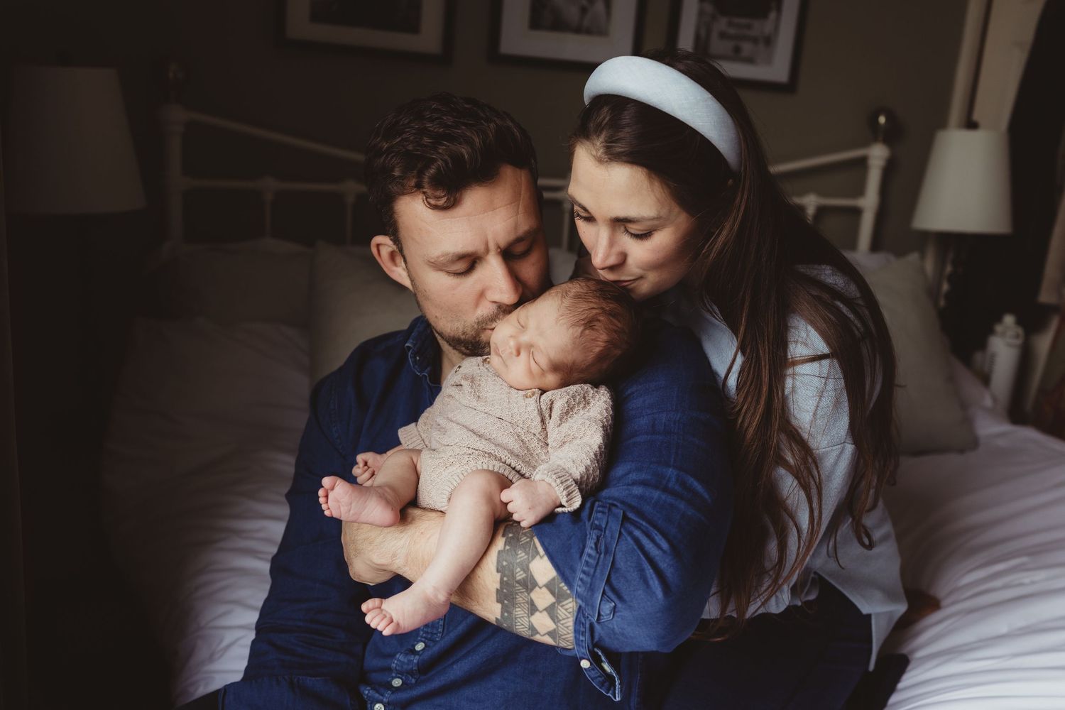 A tender sequence of parent and child sharing loving embraces while sitting on a patterned bedspread.