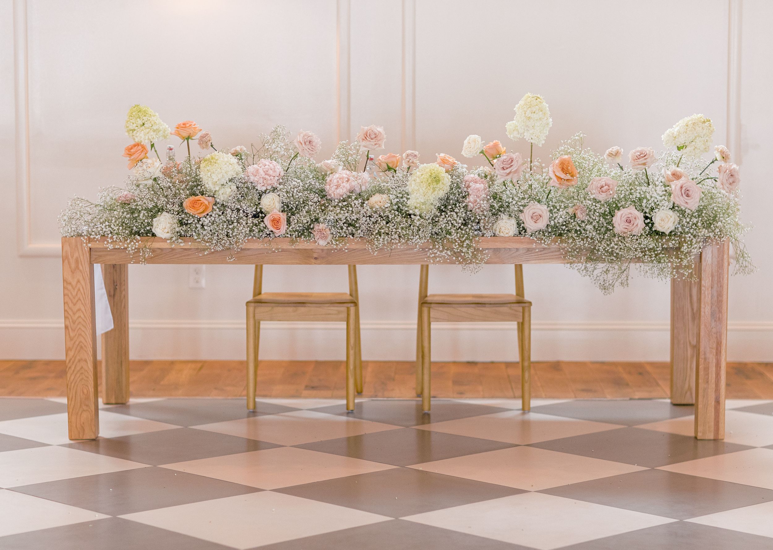 Golden floral arrangements adorn wooden benches in a minimalist church setting with romantic lighting.