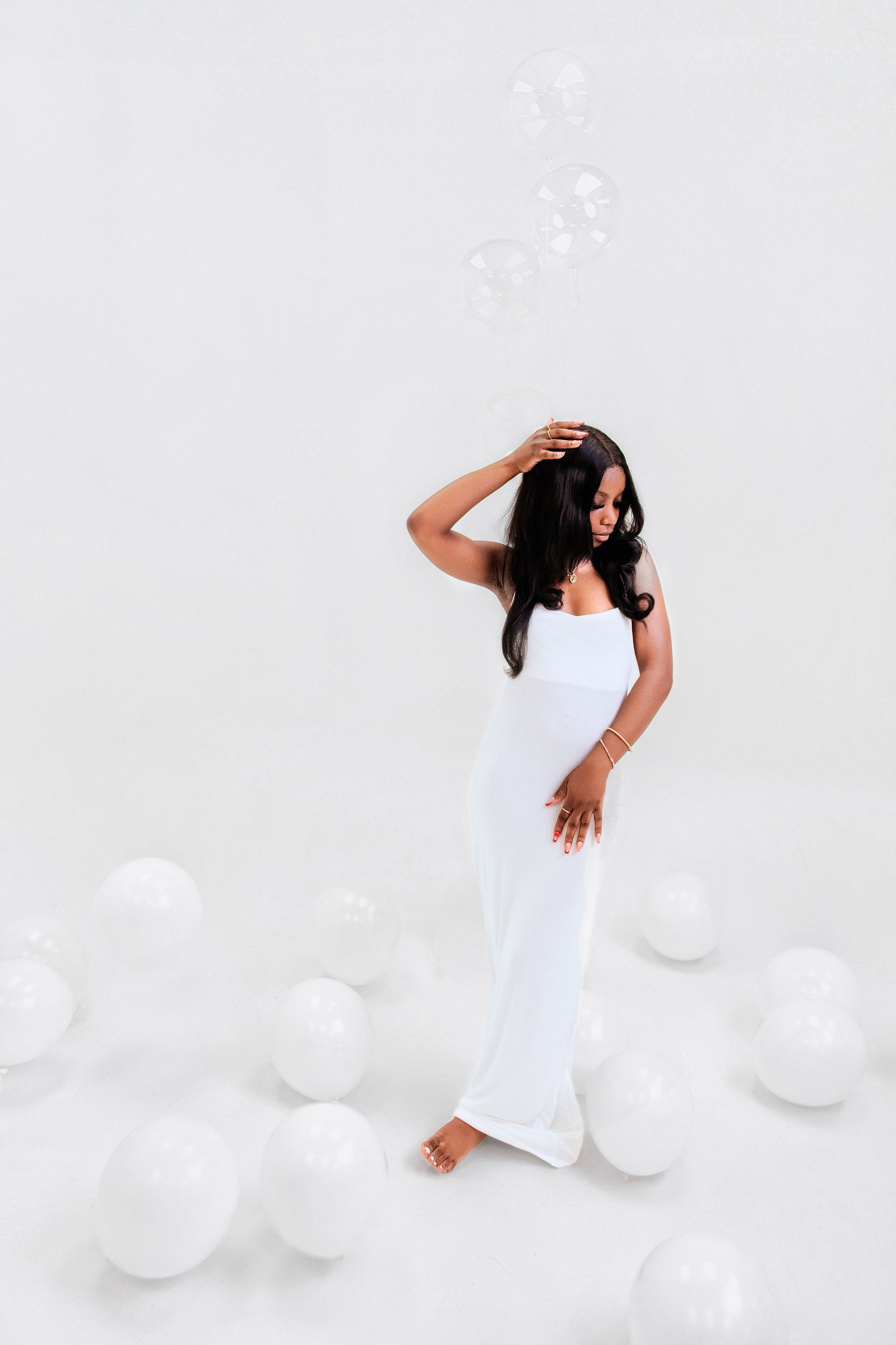 Contemporary dancer in white dress creates fluid motion sequence against white backdrop with soft lighting effects.