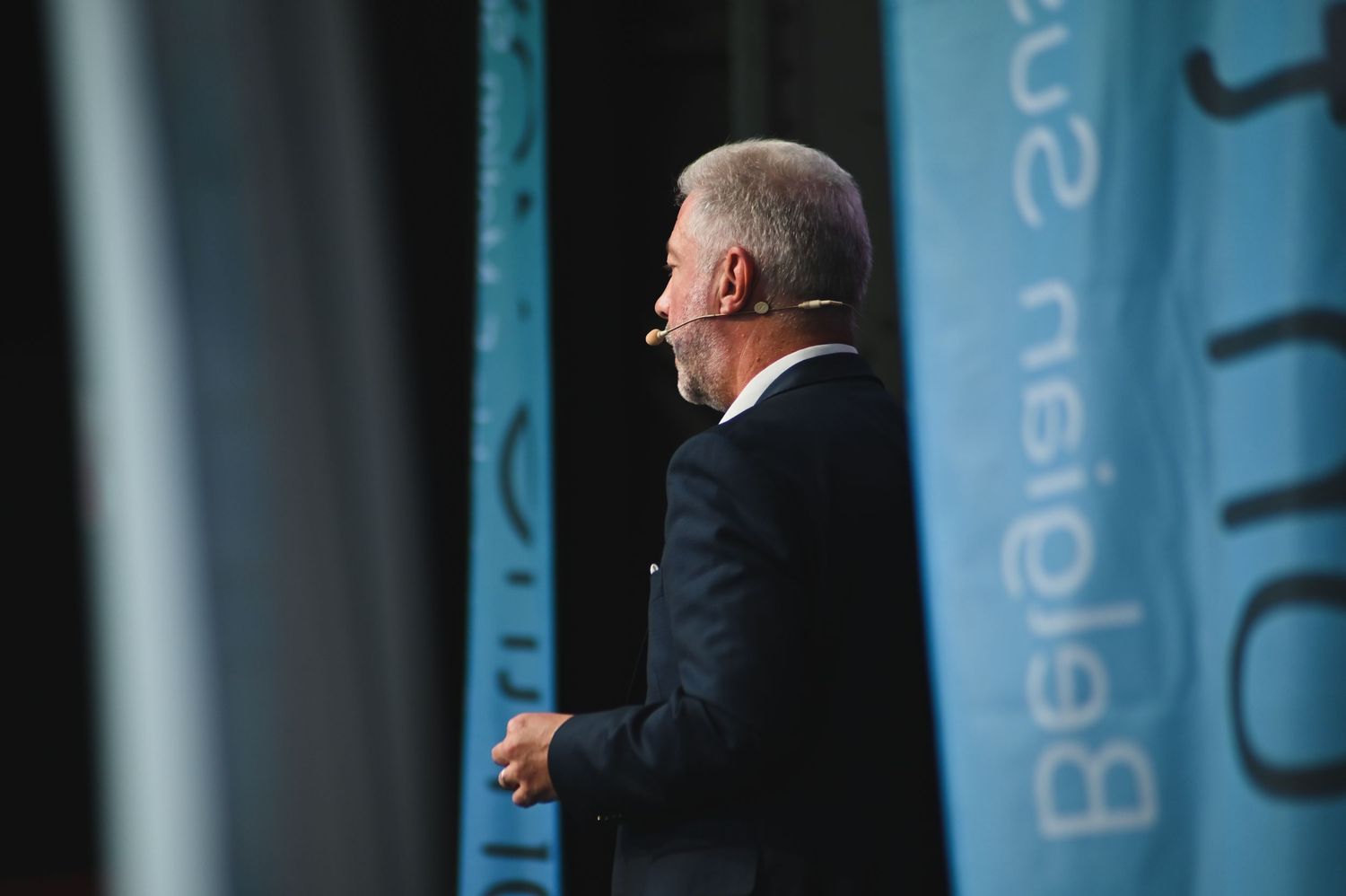 Business conference stage with blue branded backdrop and podium.