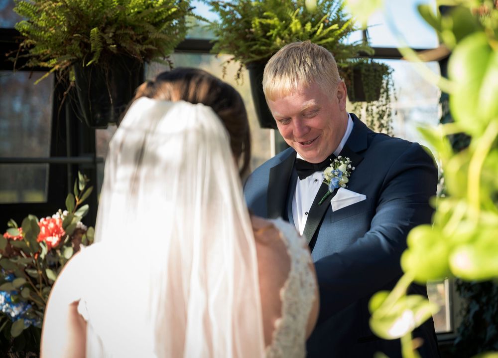 Wedding celebration in an outdoor garden setting with natural greenery and soft lighting.