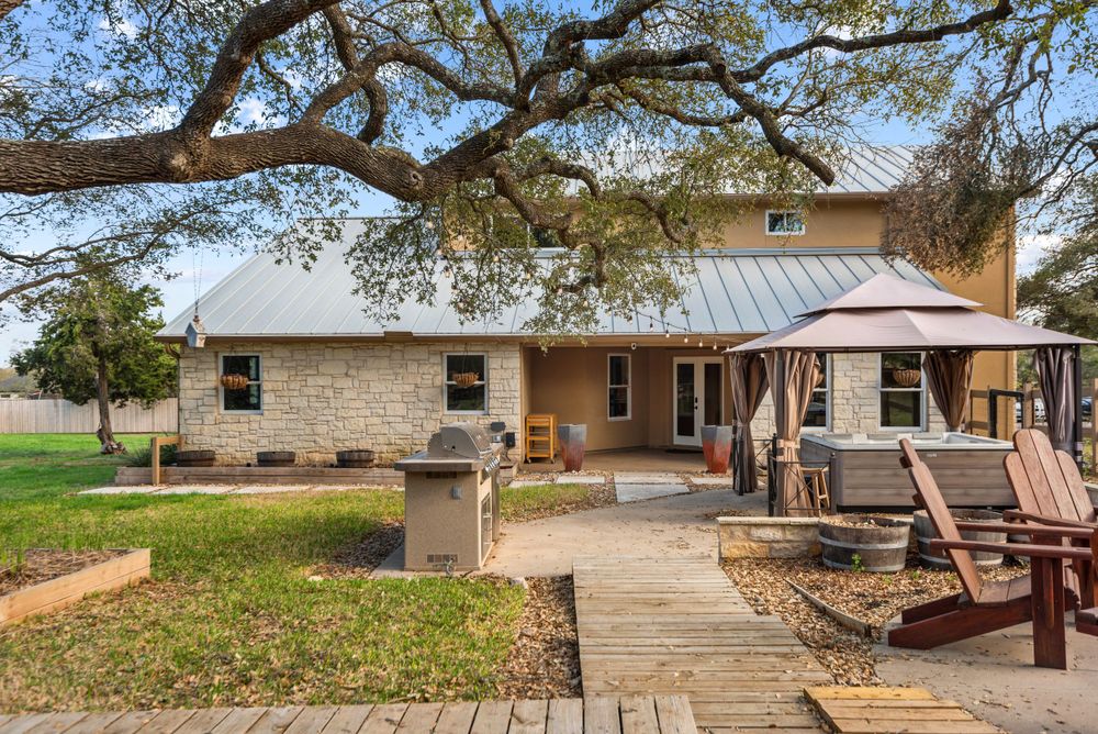 Ranch style home with covered patio, wooden deck, and outdoor living spaces.