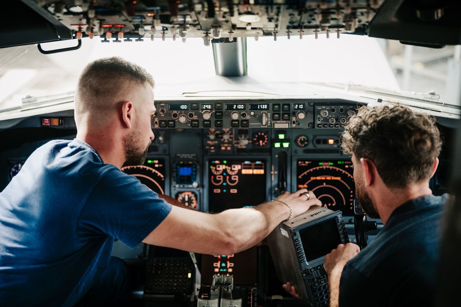 intérieur d'un cockpit d'avion avec des panneaux d'instruments éclairés pendant les mesures de deux ingénieurs de Vallair. Reportage photo