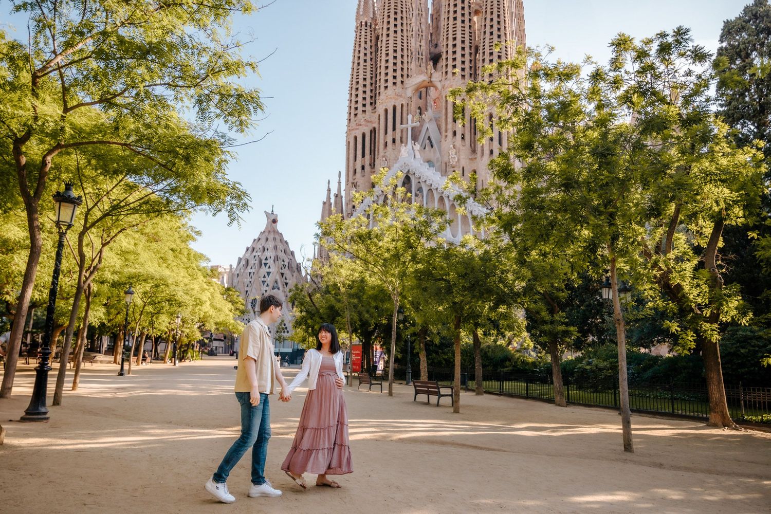 Sweet candid maternity shot of Hikari & Ricard walking near Sagrada Familia.