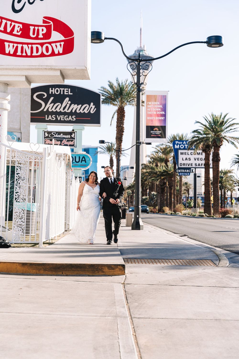 A couple walks along a palm tree-lined street outside the Little White Wedding Chapel in Las Vegas.