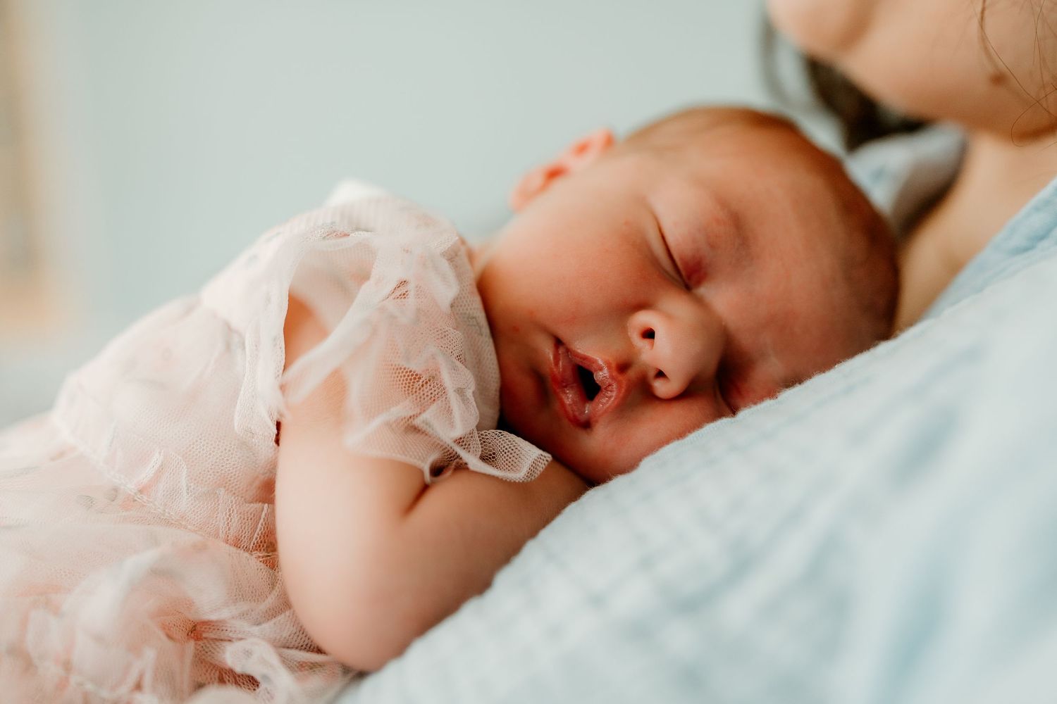 Baby sleeping on her mother during a home photoshoot session