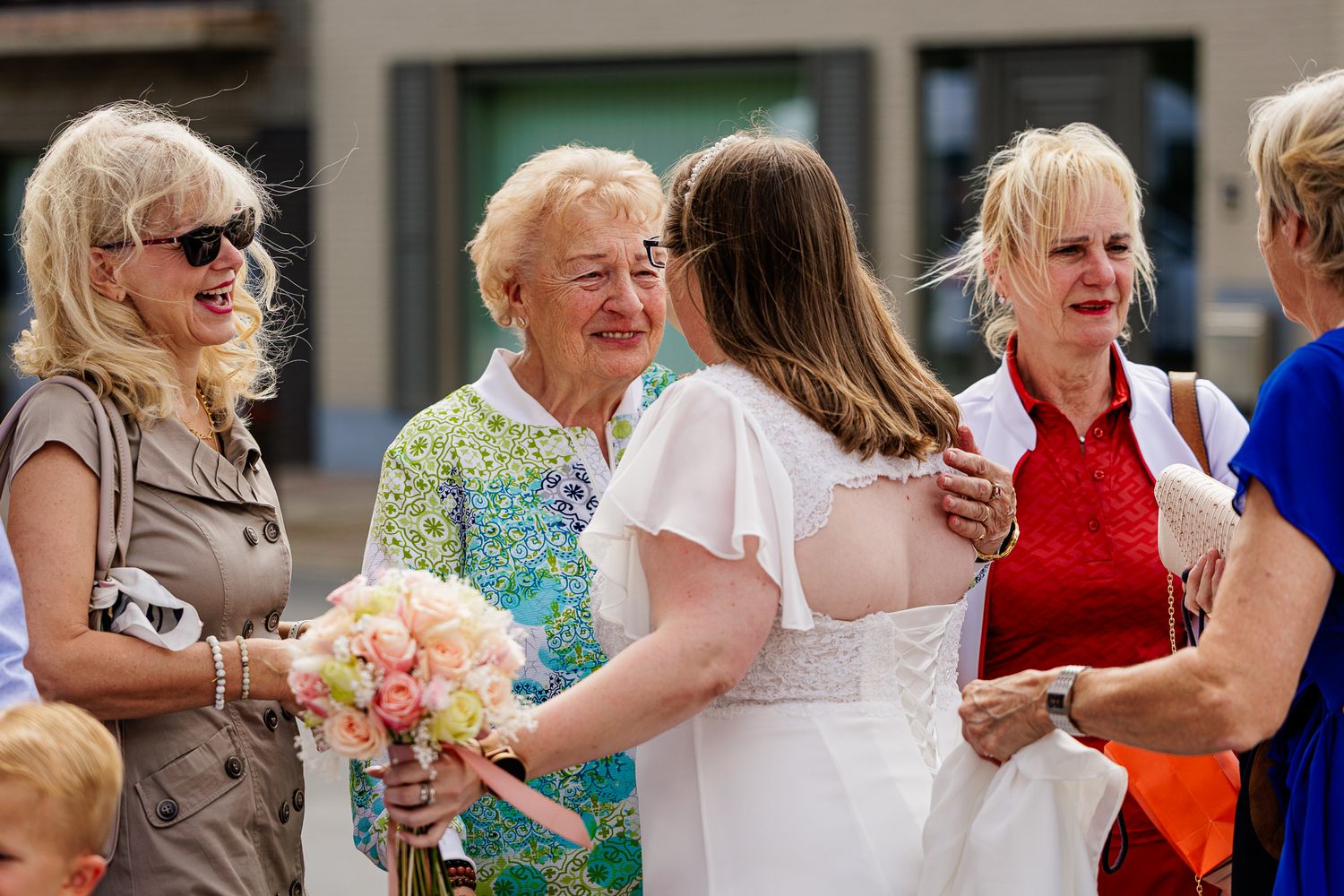 A group of wedding guests dancing together in a line at a celebration.