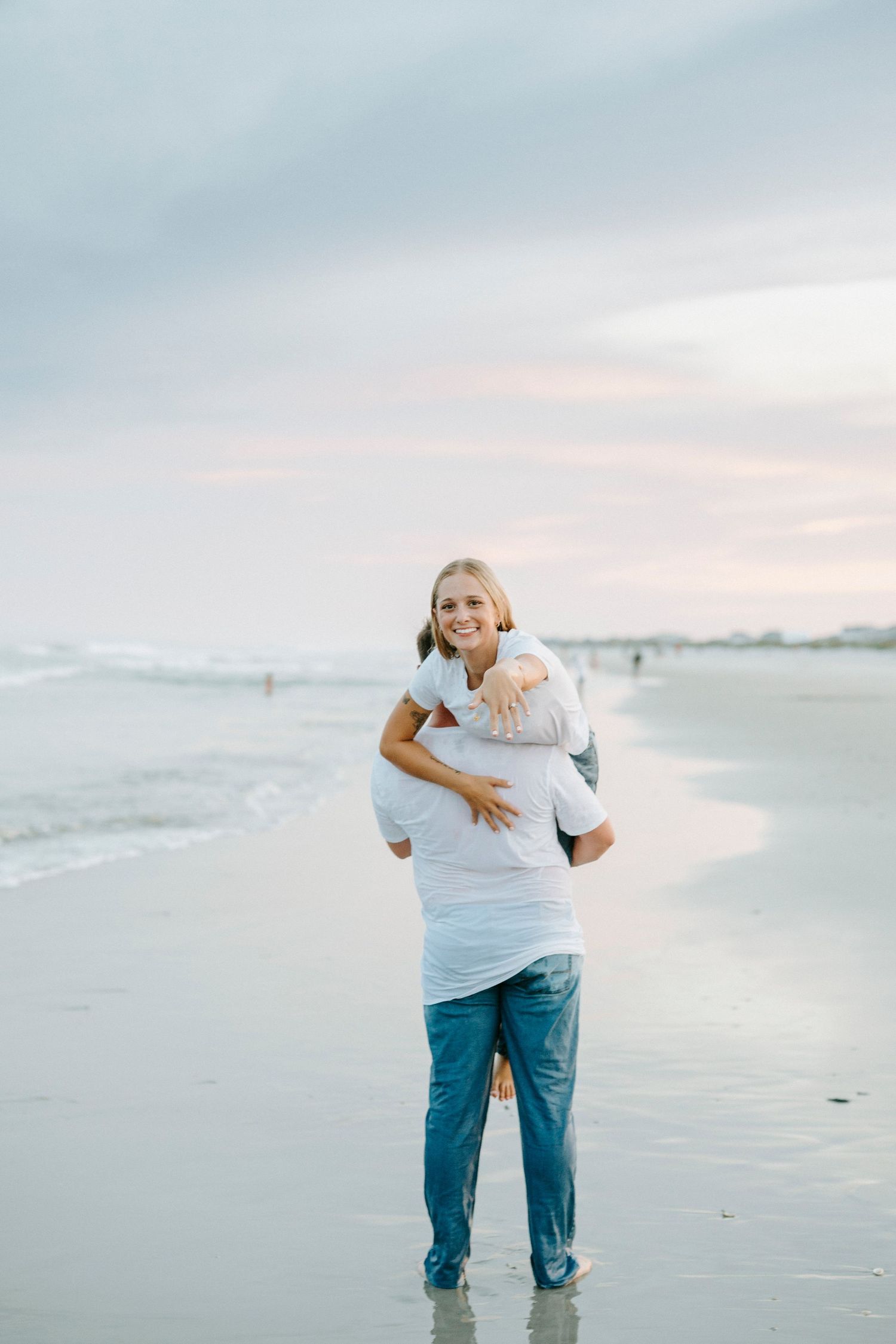 A couple shares tender moments while walking together along a peaceful beach at sunset.