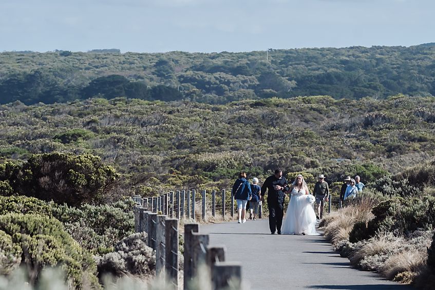 A wooden boardwalk pathway stretches across rugged coastal terrain with sweeping views of the ocean and landscape.