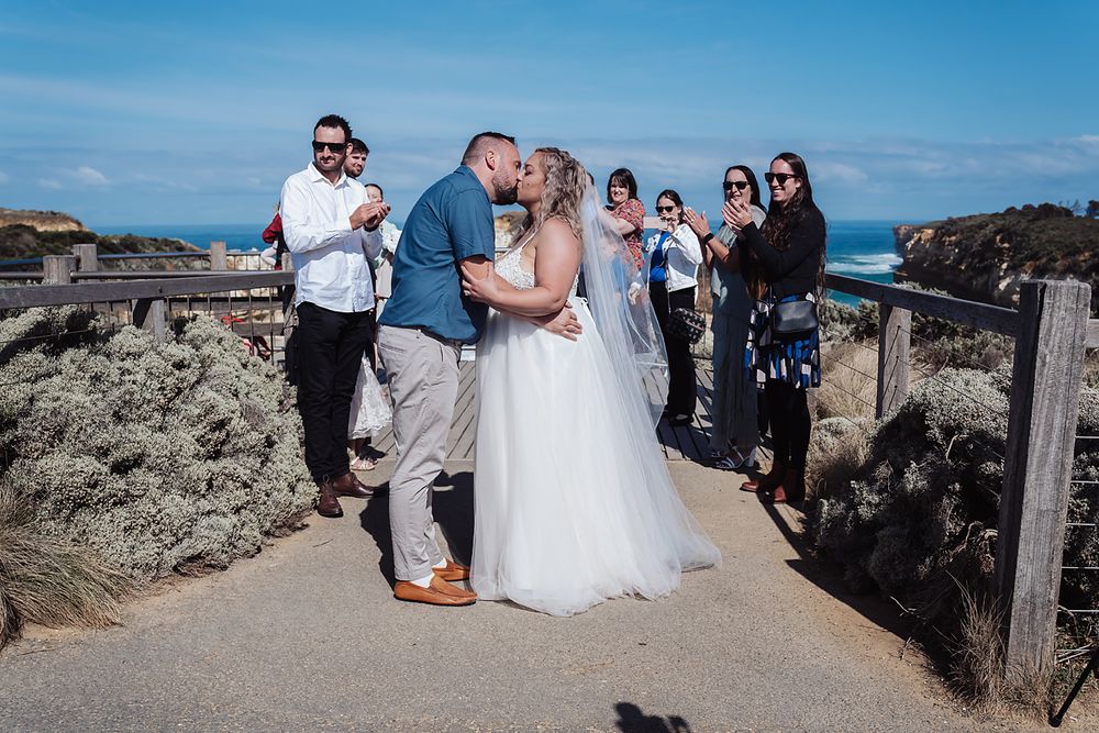 Wedding party and guests gather at a scenic coastal viewpoint with dramatic cliffs and ocean vistas.