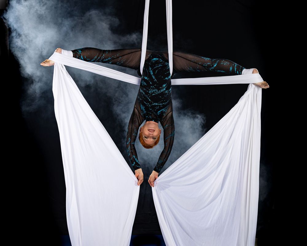 Artistic dance sequence showing flowing white fabric against dark background with dramatic smoke effects.