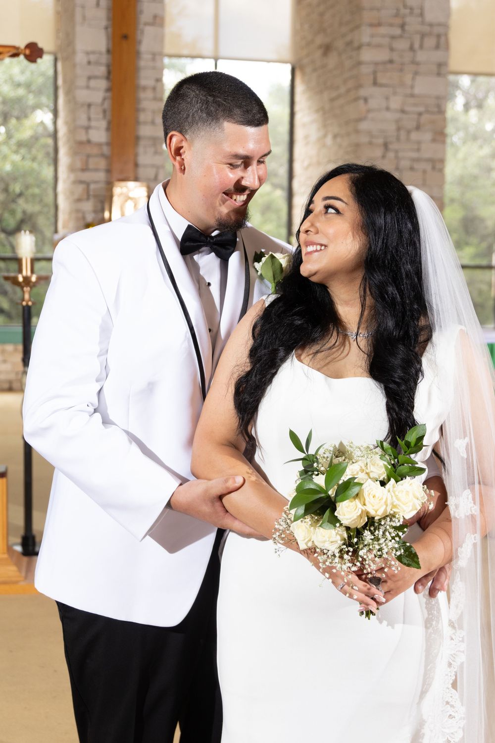 A romantic wedding couple shares intimate moments in a series of photos with brick columns in the background.