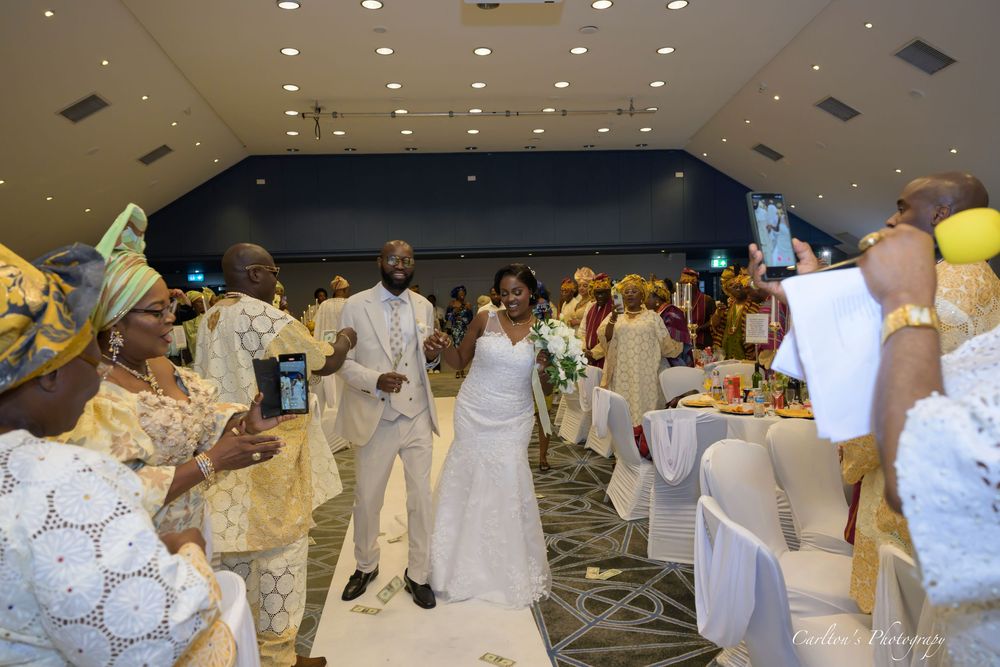 Traditional dancers in white garments performing choreographed movements during a cultural celebration event.
