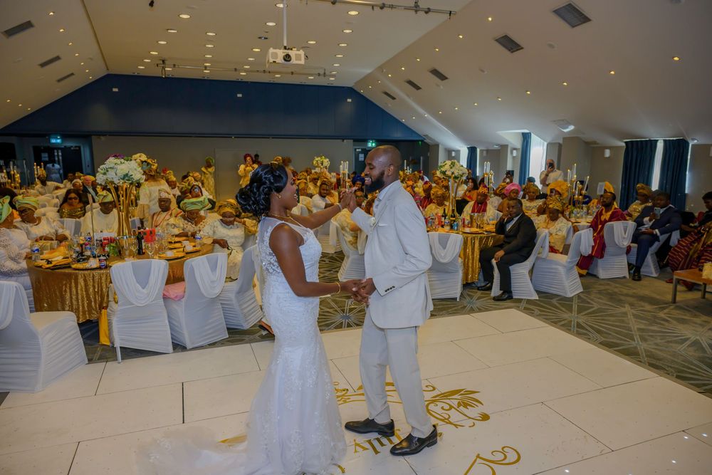 A large white indoor venue with multiple rows of seating and tables decorated for a special event or celebration.