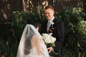 Bride and groom share intimate moments during their wedding photoshoot in a lush garden setting.