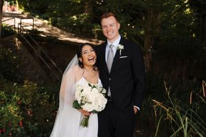 A joyful moment captured during a wedding ceremony in an outdoor wooded setting with natural lighting.