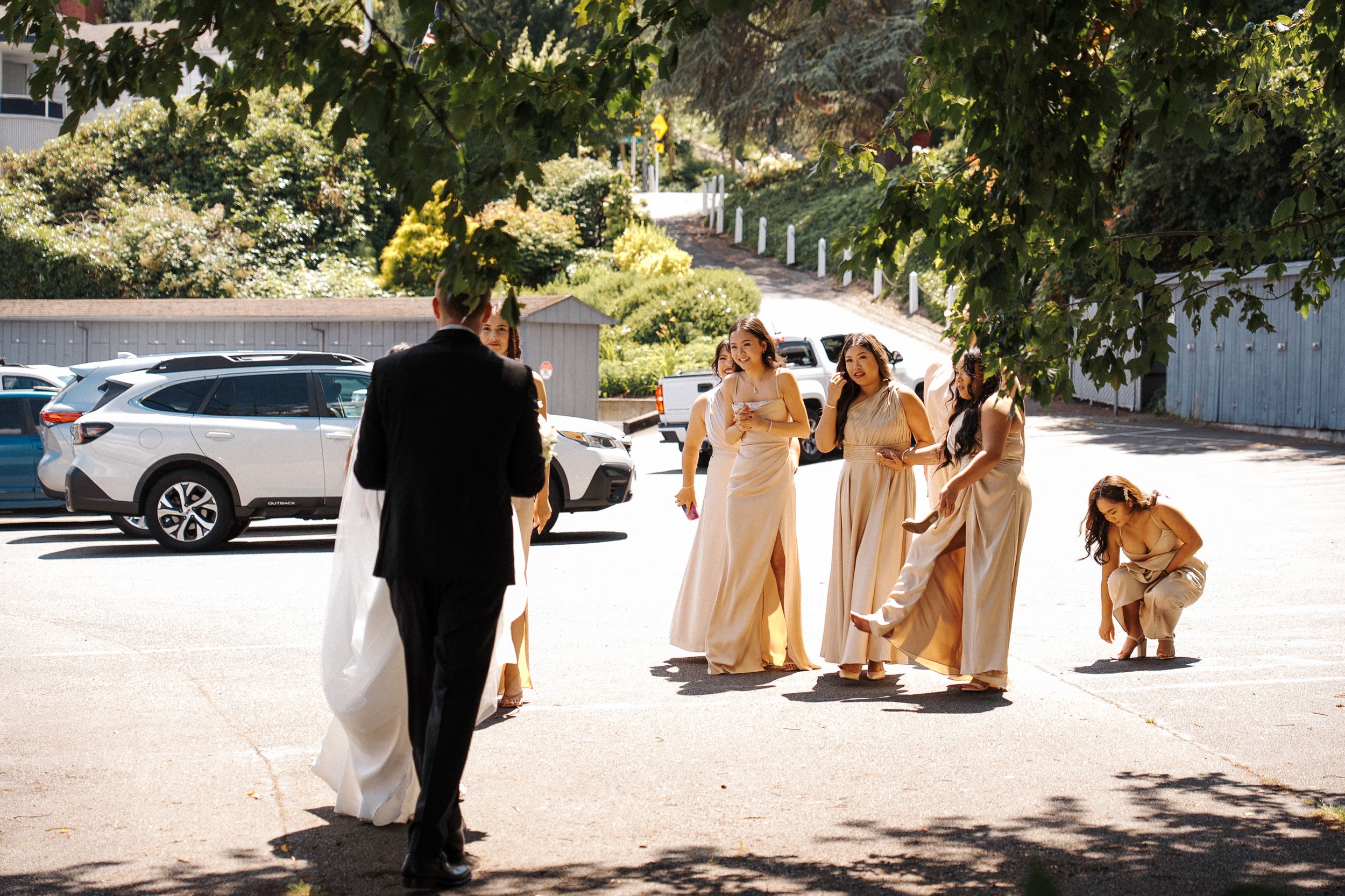 A group wearing traditional golden wedding attire walks together on a sunny path outdoors.