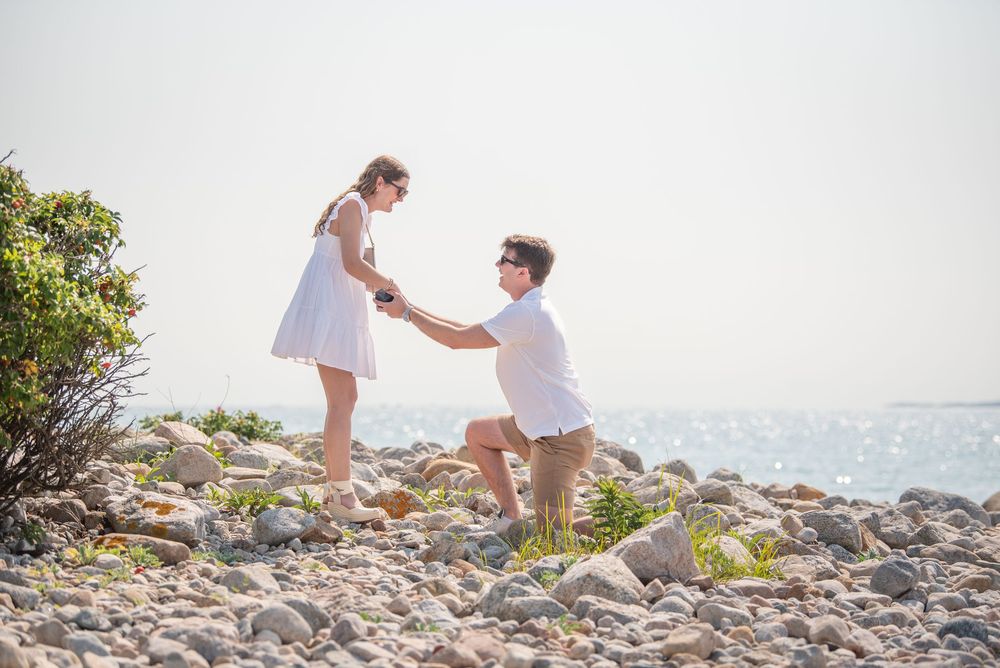 Couple sharing special moment during beach proposal with ocean view.