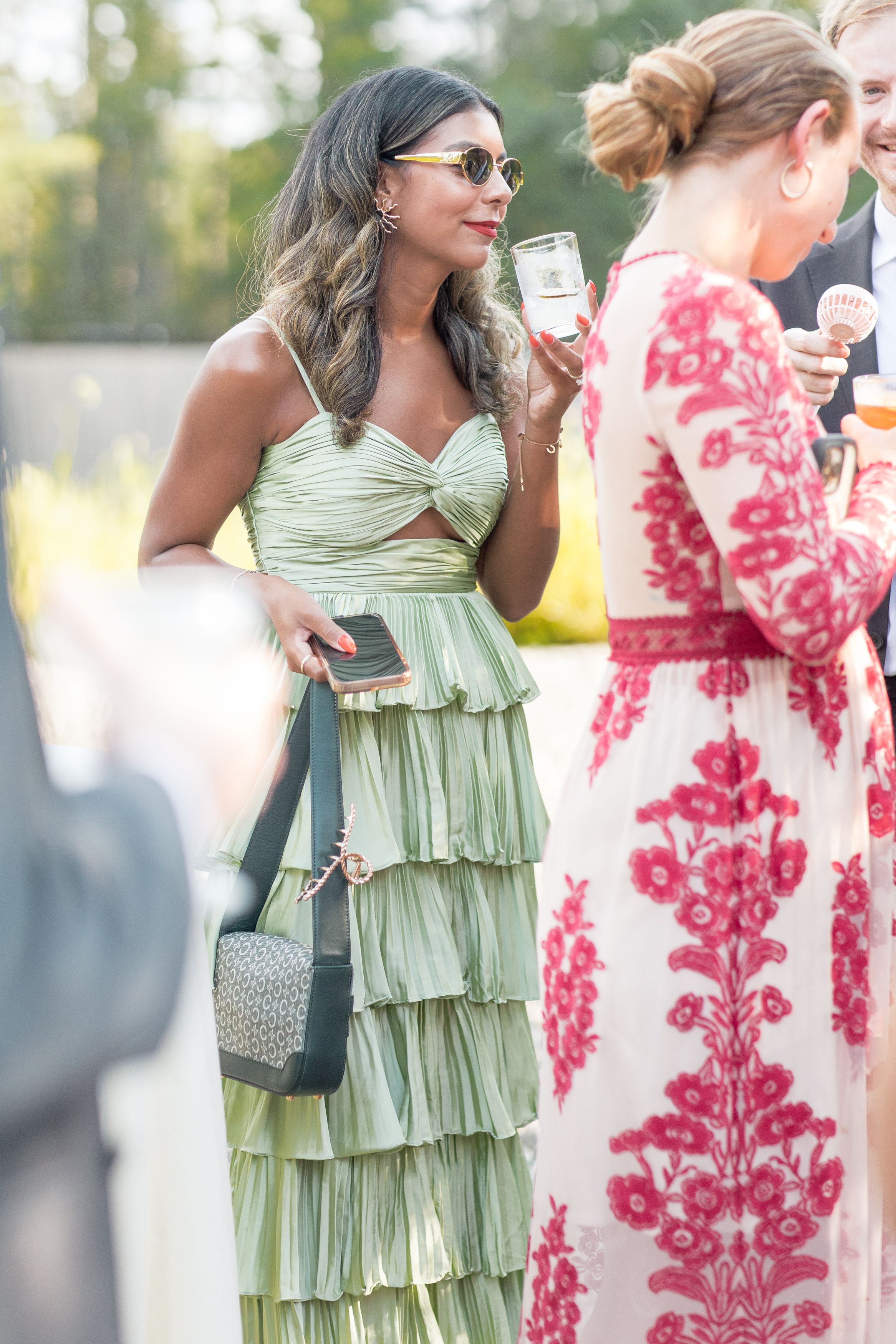 Close-up collage of dresses in mint green and coral pink floral patterns at an elegant outdoor gathering.