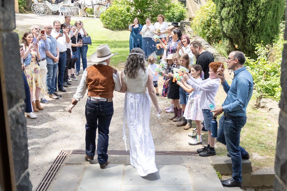 A couple shares their first dance together at a daytime garden wedding celebration surrounded by applauding guests.