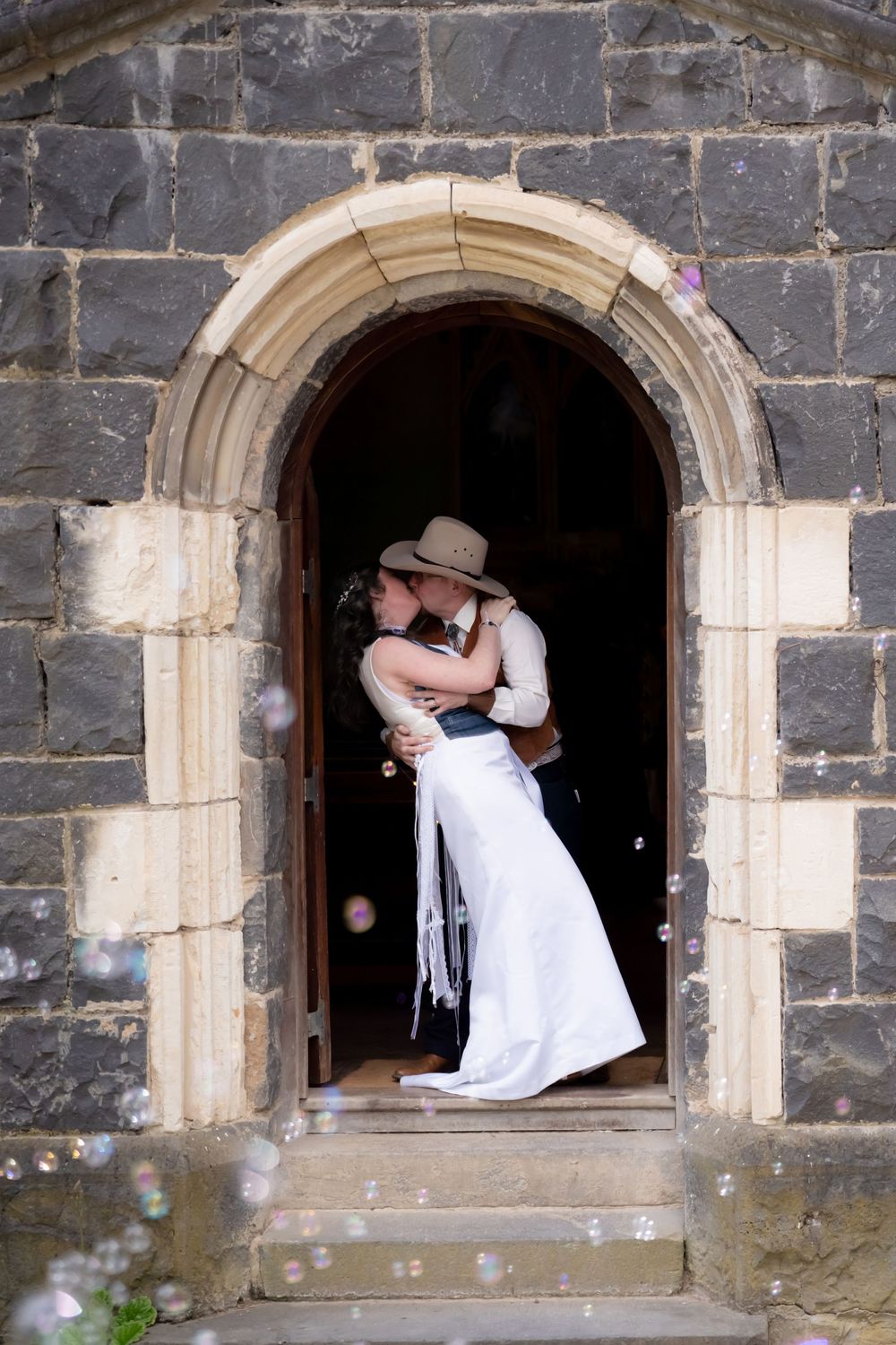 A series of archway photos shows a romantic wedding couple's portraits taken in an old stone alcove frame.