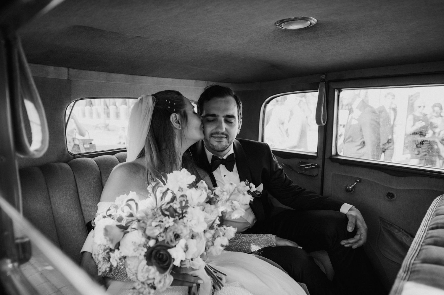Newly married couple sitting in a vintage car