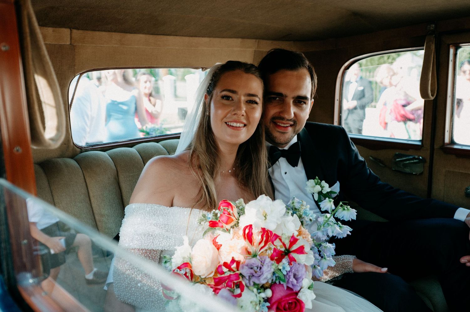 Newly married couple sitting in a vintage car