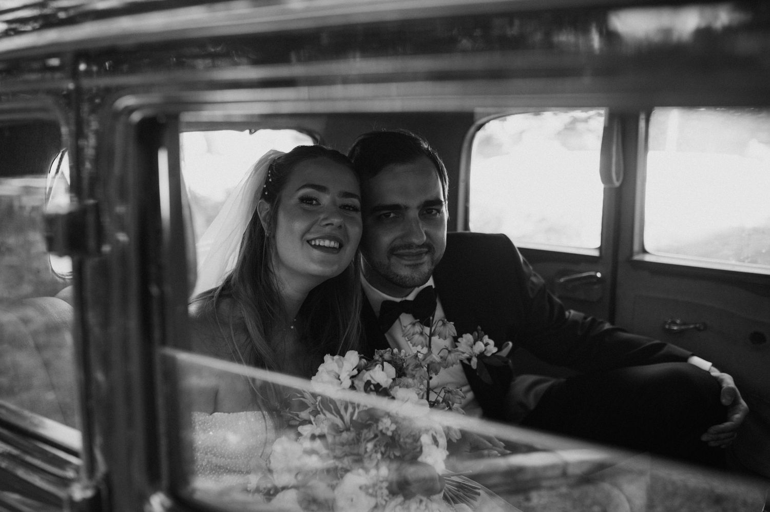 Newly married couple sitting in a vintage car