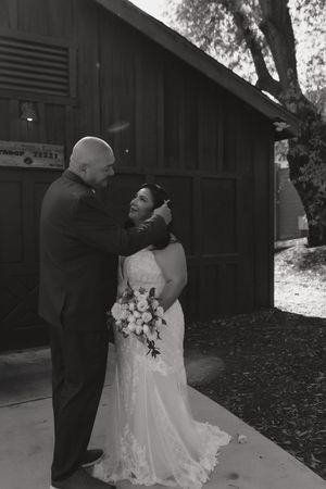 Black and white sequence of romantic outdoor wedding photos near a rustic barn building.