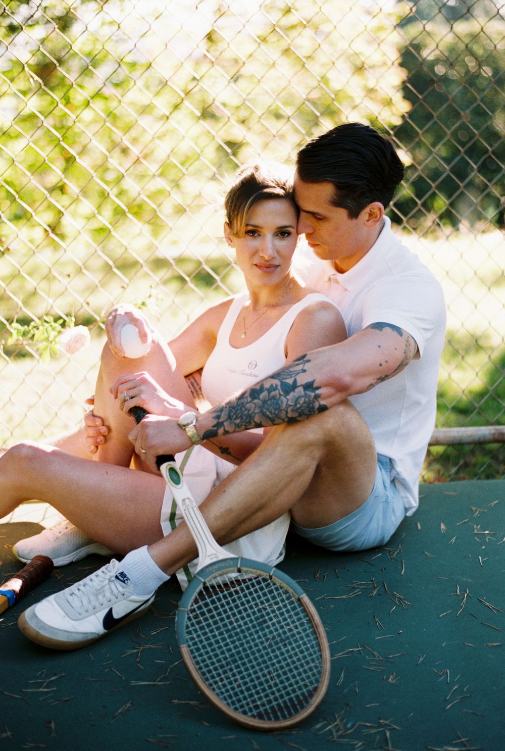 Couple sitting together by tennis court sharing affectionate moments across four sequential poses.