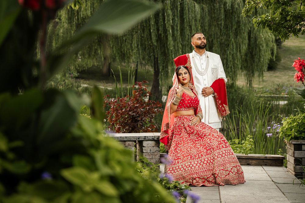 Garden photoshoot among flowering bushes and weeping willows on a sunny day.