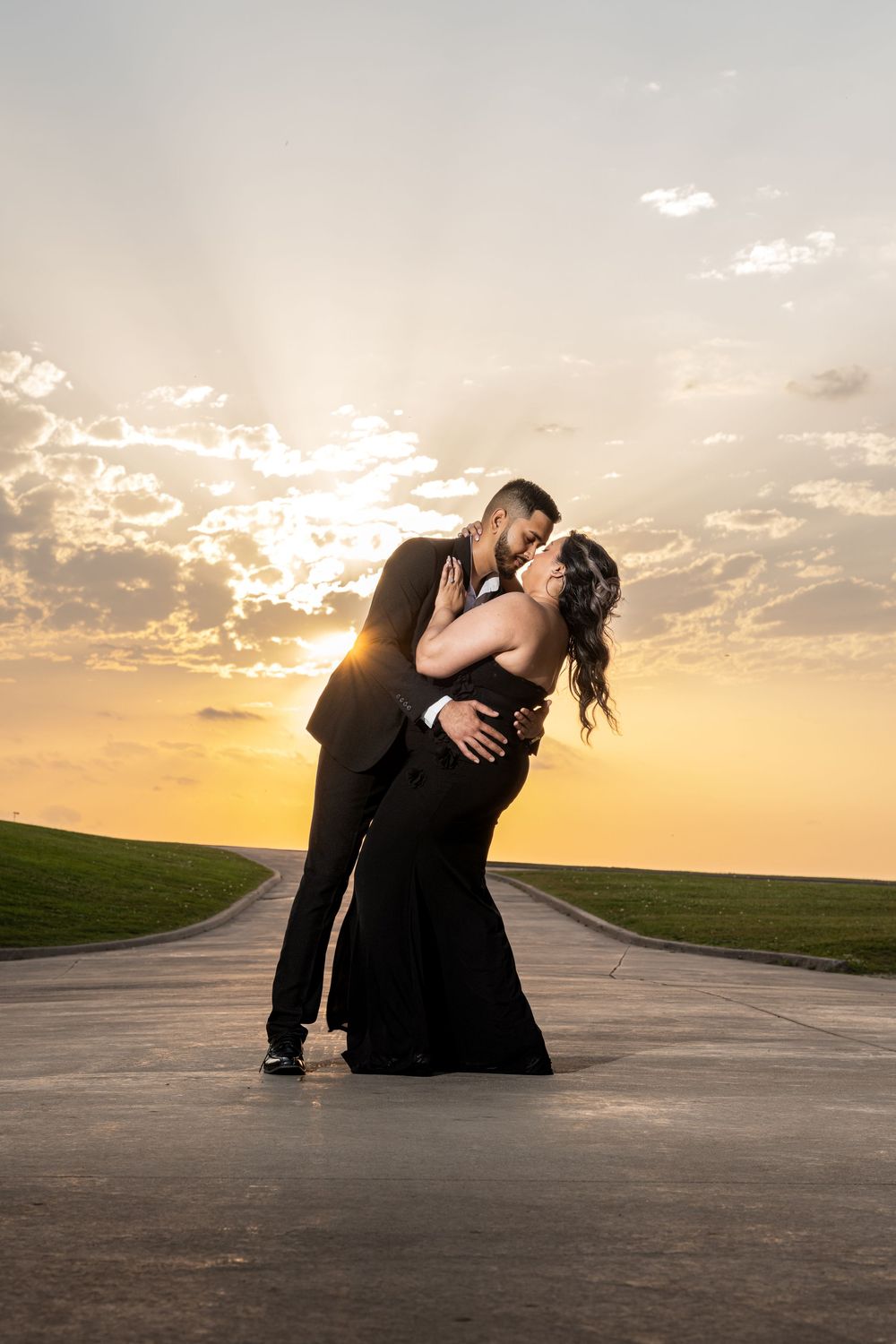 Dramatic sunset silhouette dance poses on empty road at golden hour.