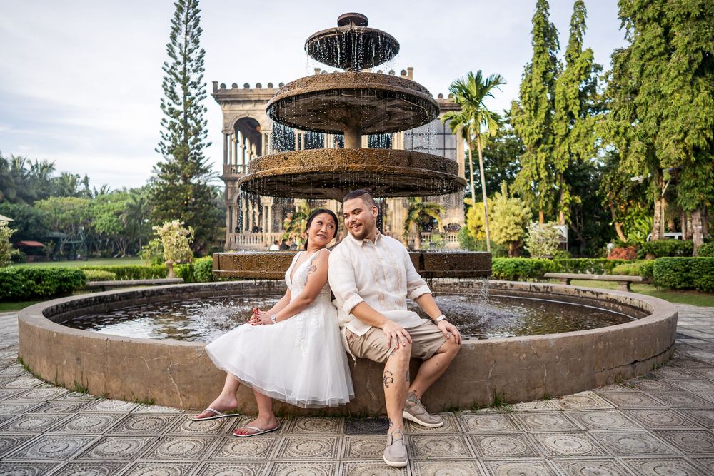 Relaxed outdoor photoshoot by historic fountain surrounded by tropical architecture.