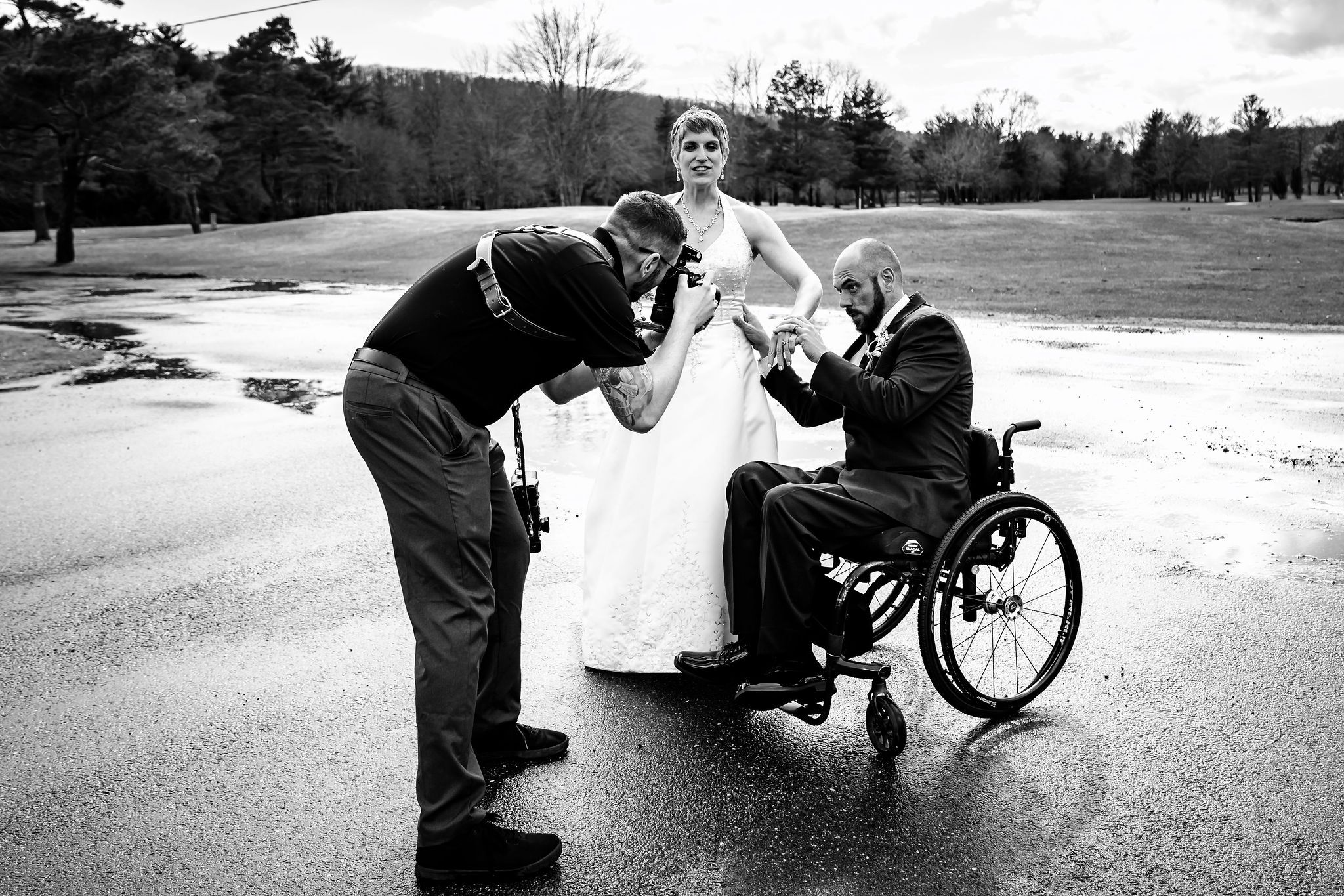 Black and white series showing outdoor wedding photography session near a wheelchair.