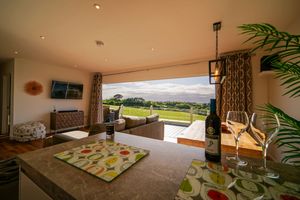 Luxurious covered lanai with comfortable seating and stunning views of the Hawaiian landscape and ocean beyond.