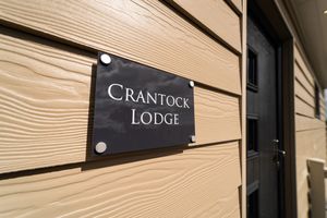 Close-up view of a wooden wall panel installation with horizontal slats and black signage details.