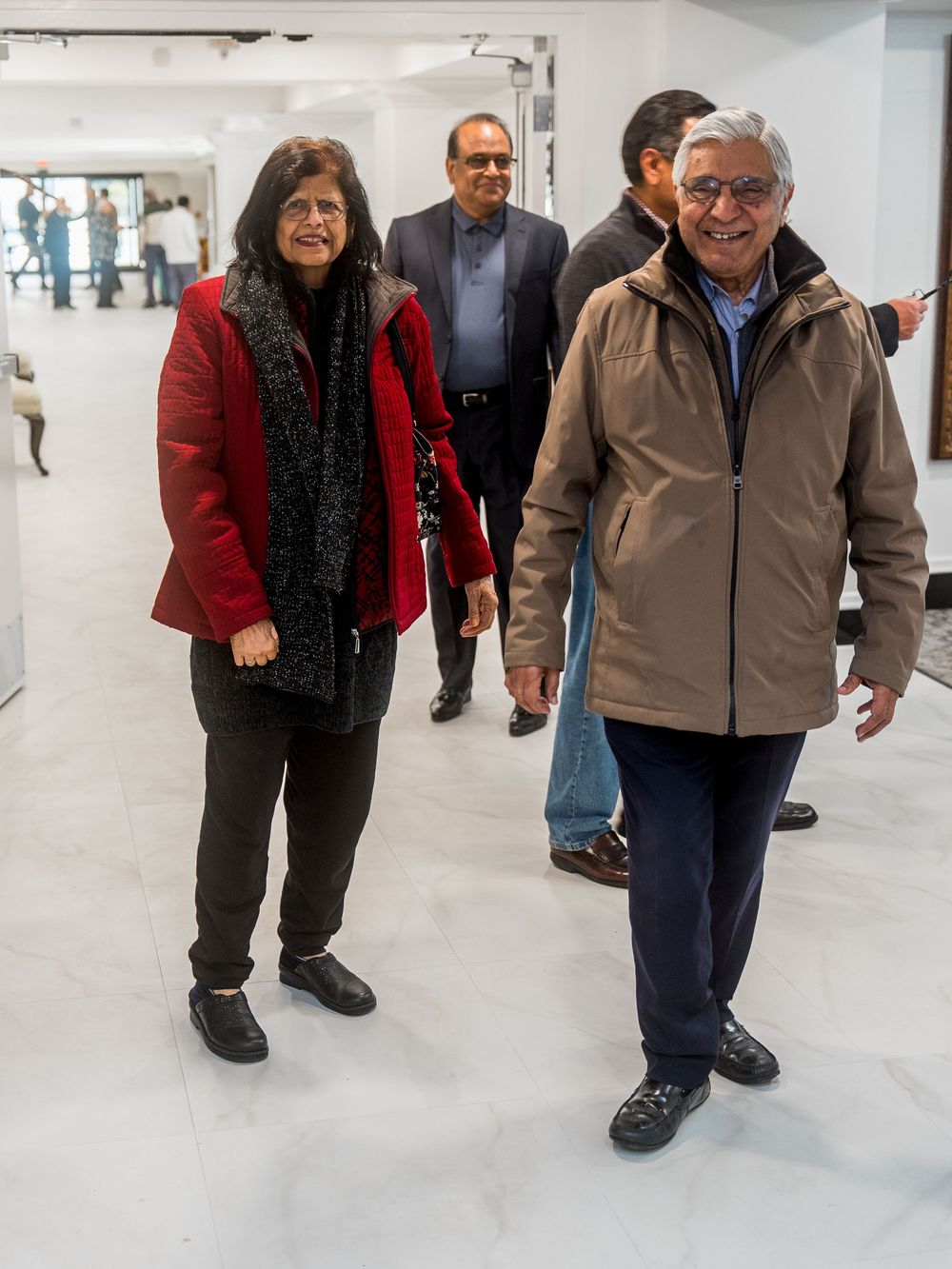 A sequence of walking shots showing two people walking together in an indoor hallway or corridor.